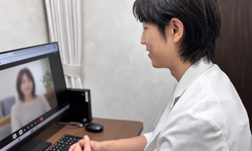 パソコンの画面越しに患者と話す医師（オンライン診療）