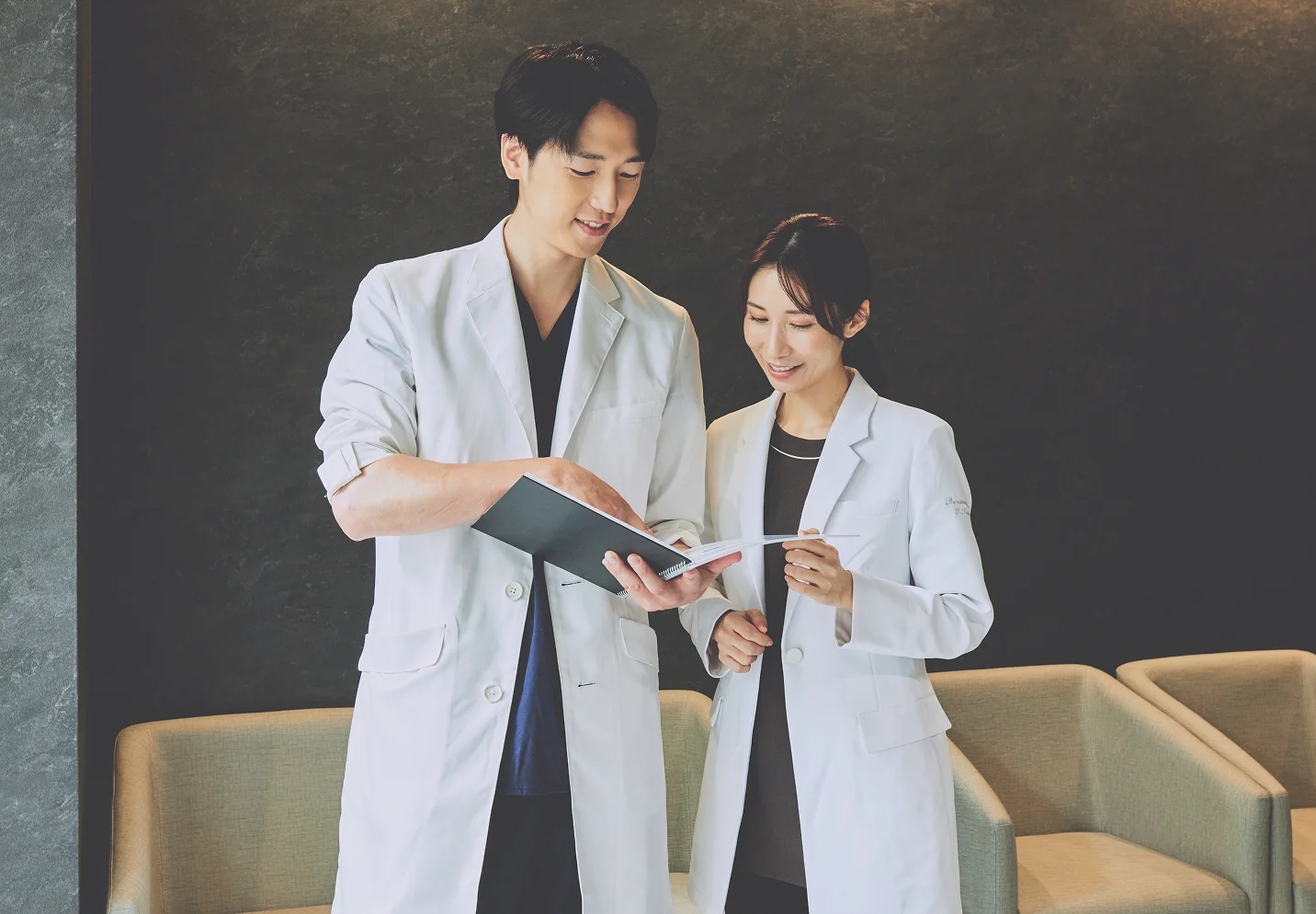 診察室で患者と向き合い笑顔で話す医師