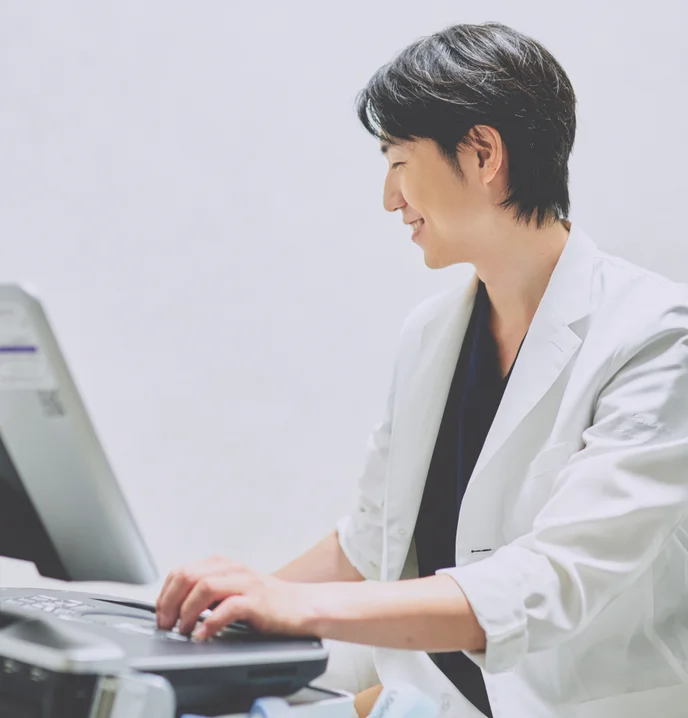 超音波診断装置を操作して検査を行う医師