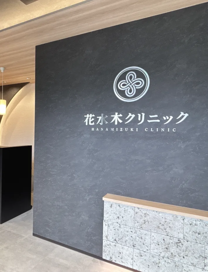 花水木クリニックのロゴサインを掲げた受付前の壁